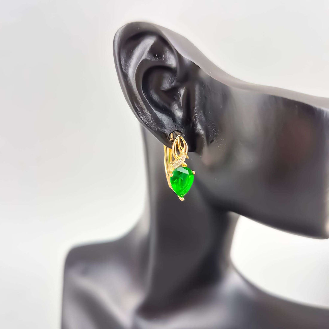 Green teardrop earring with leverback worn on black mannequin ear
