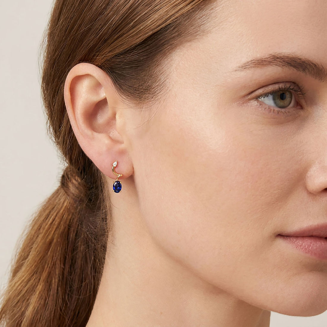 Earrings with a dark blue stone