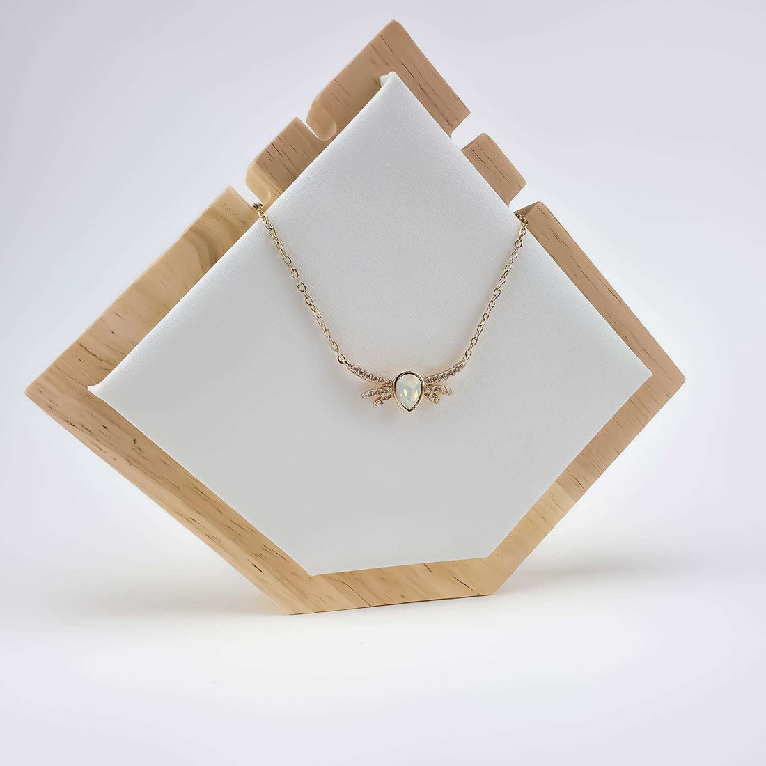 Winged necklace on a wooden jewellery stand with a soft white pear stone