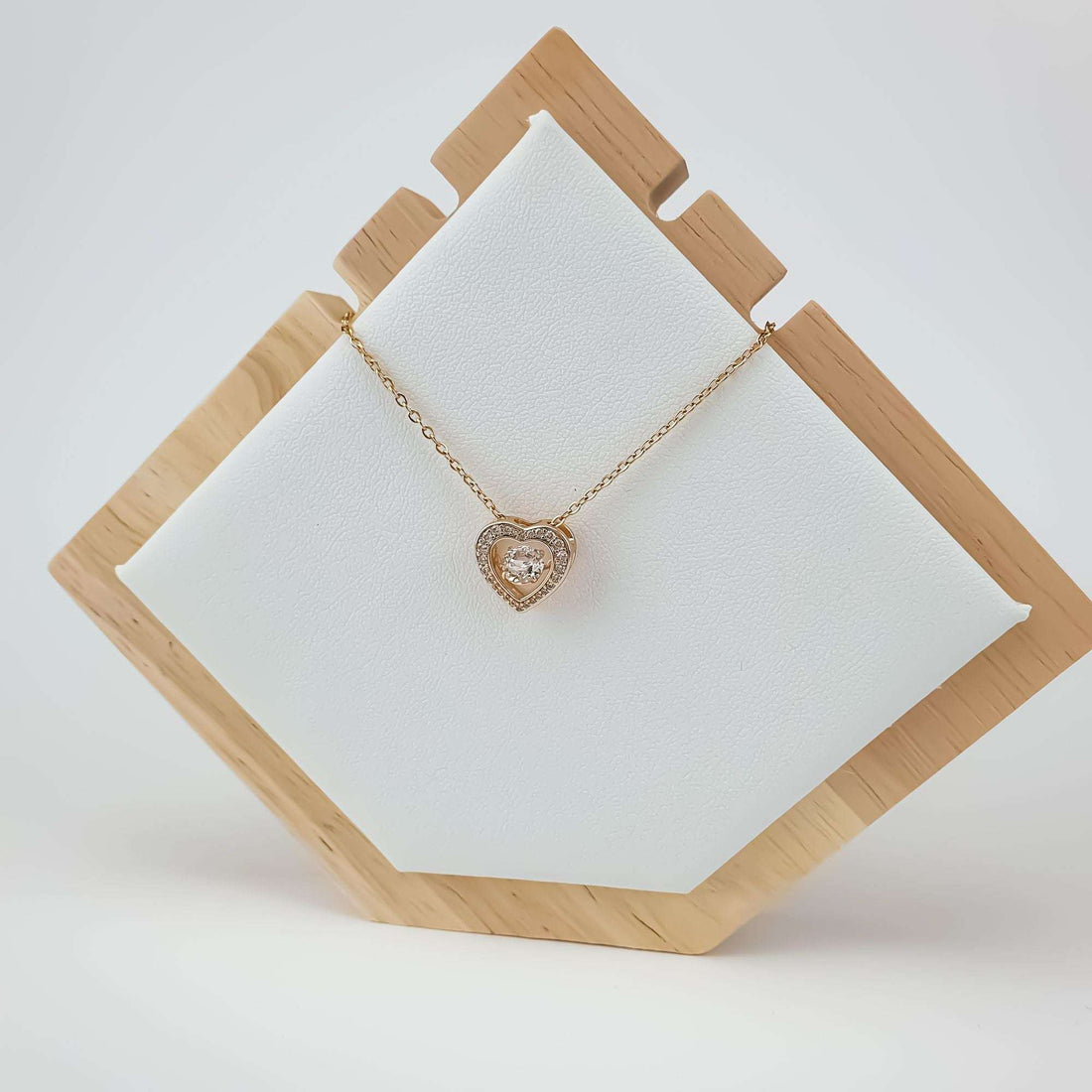Double heart pendant necklace on a white jewellery tray in a wooden frame