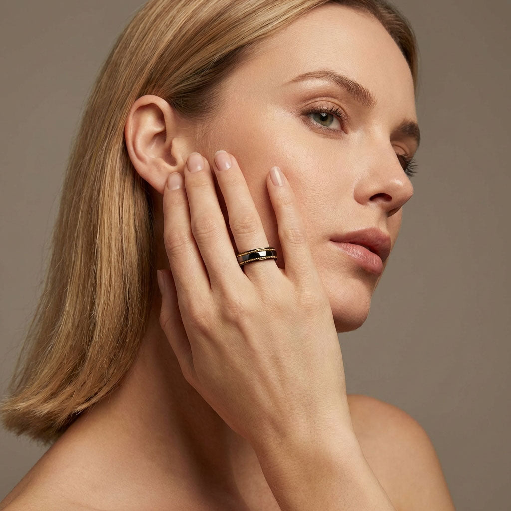 Model wearing the black ceramic ring with twisted gold-tone accents