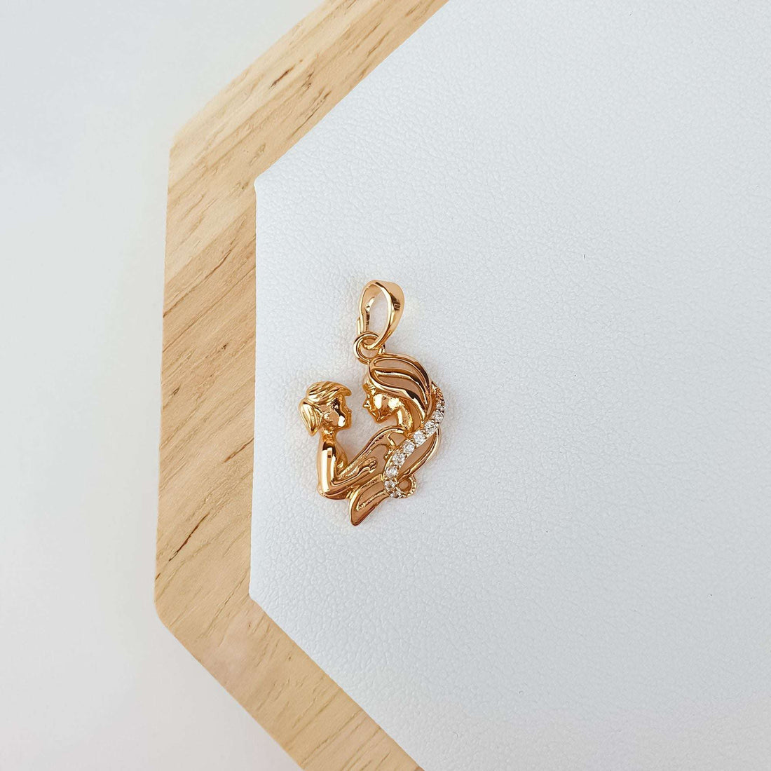 Mother and child pendant lying on a light leather surface