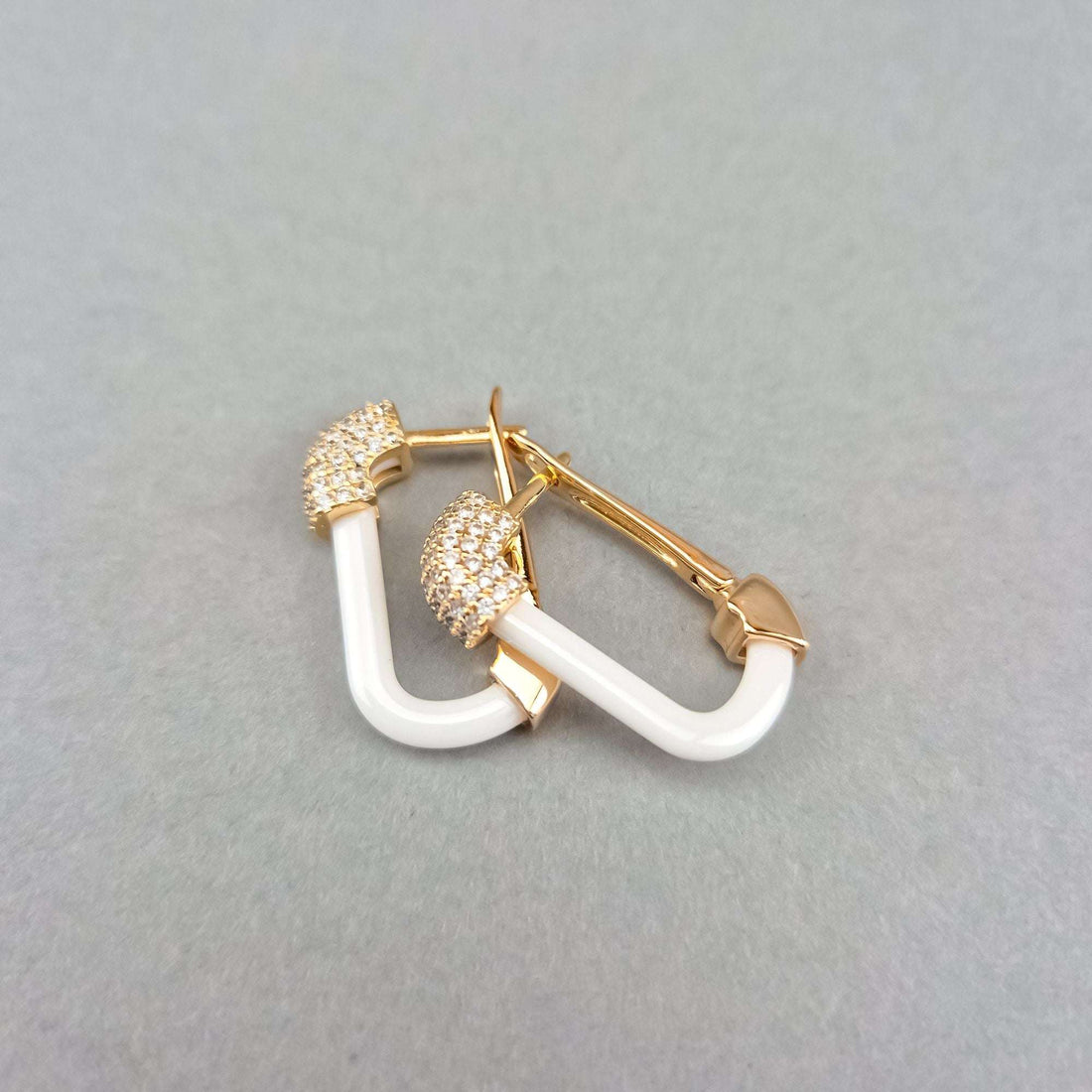Ceramic earrings at an angle showing the leverback clasp, grey background