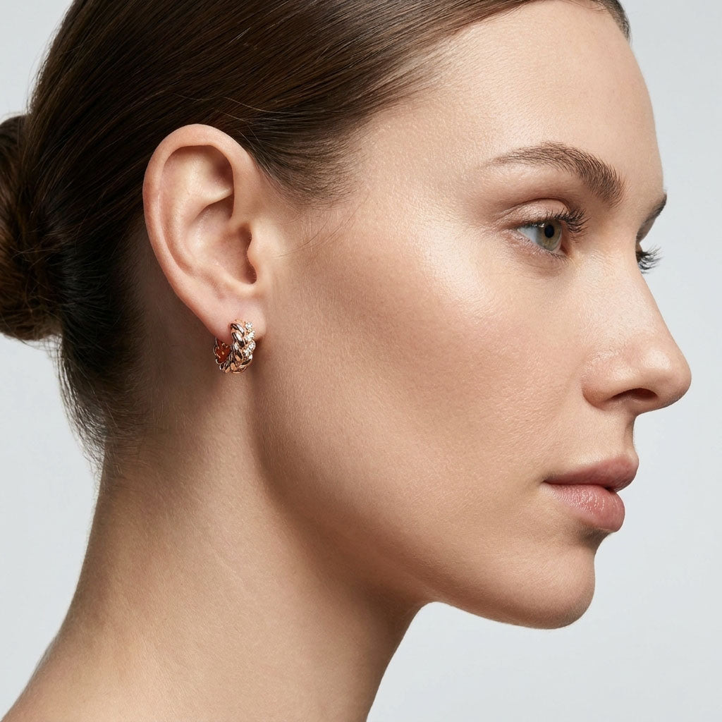 Model wearing a plaited gold-plated hoop earring with cubic zirconia, side view