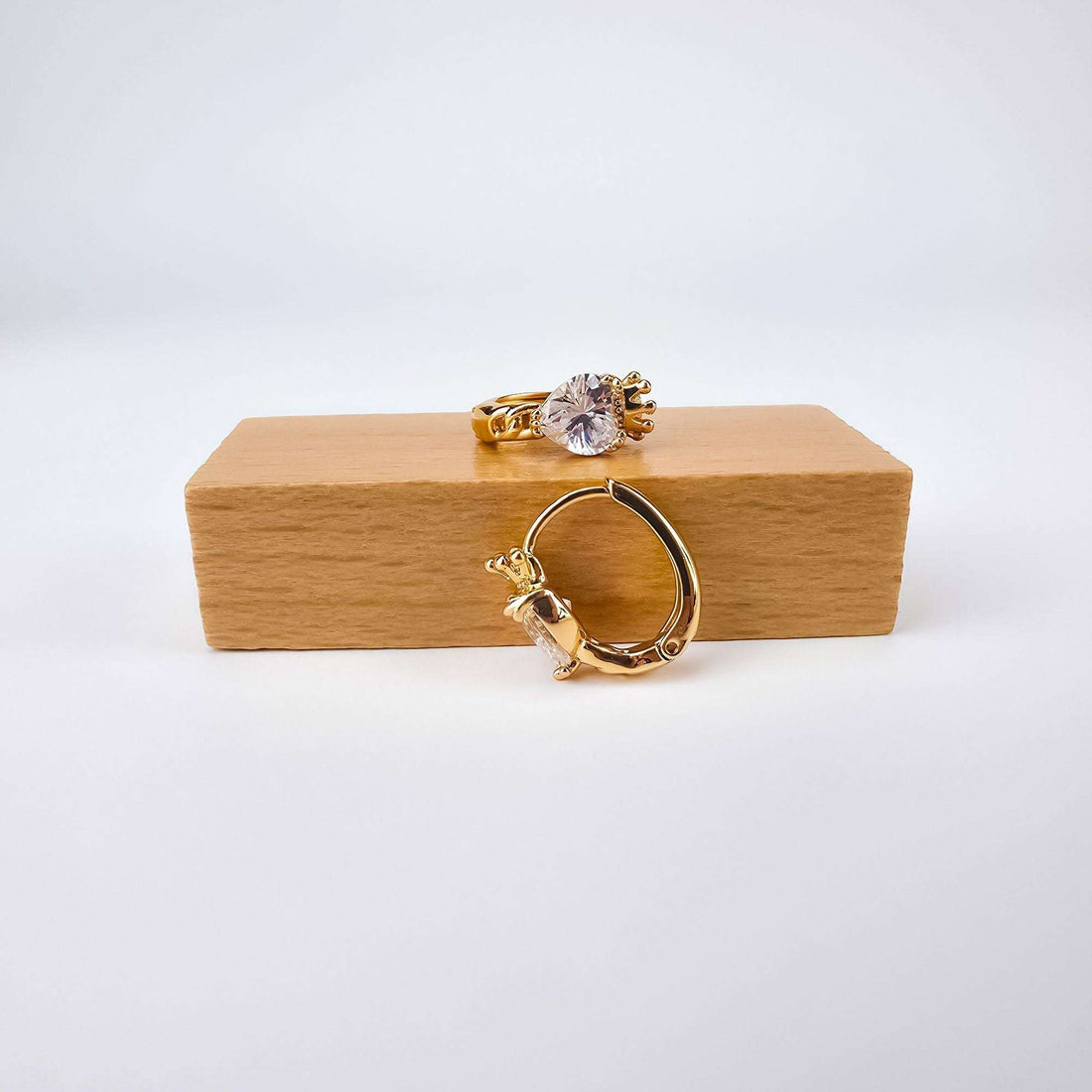 Heart and crown earrings with cubic zirconia on a wooden stand