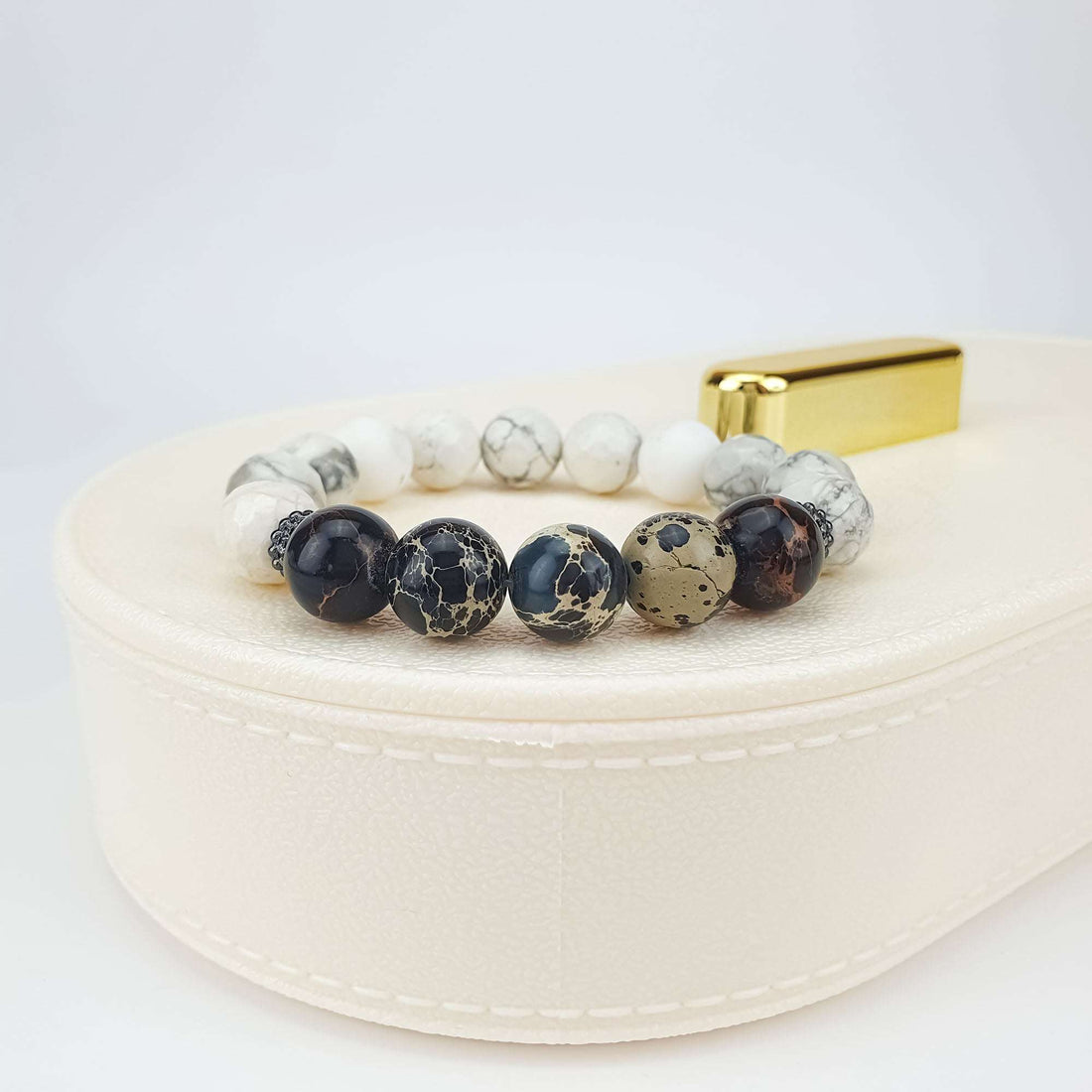 Howlite and nephrite bracelet on a light box, side view of marbled beads