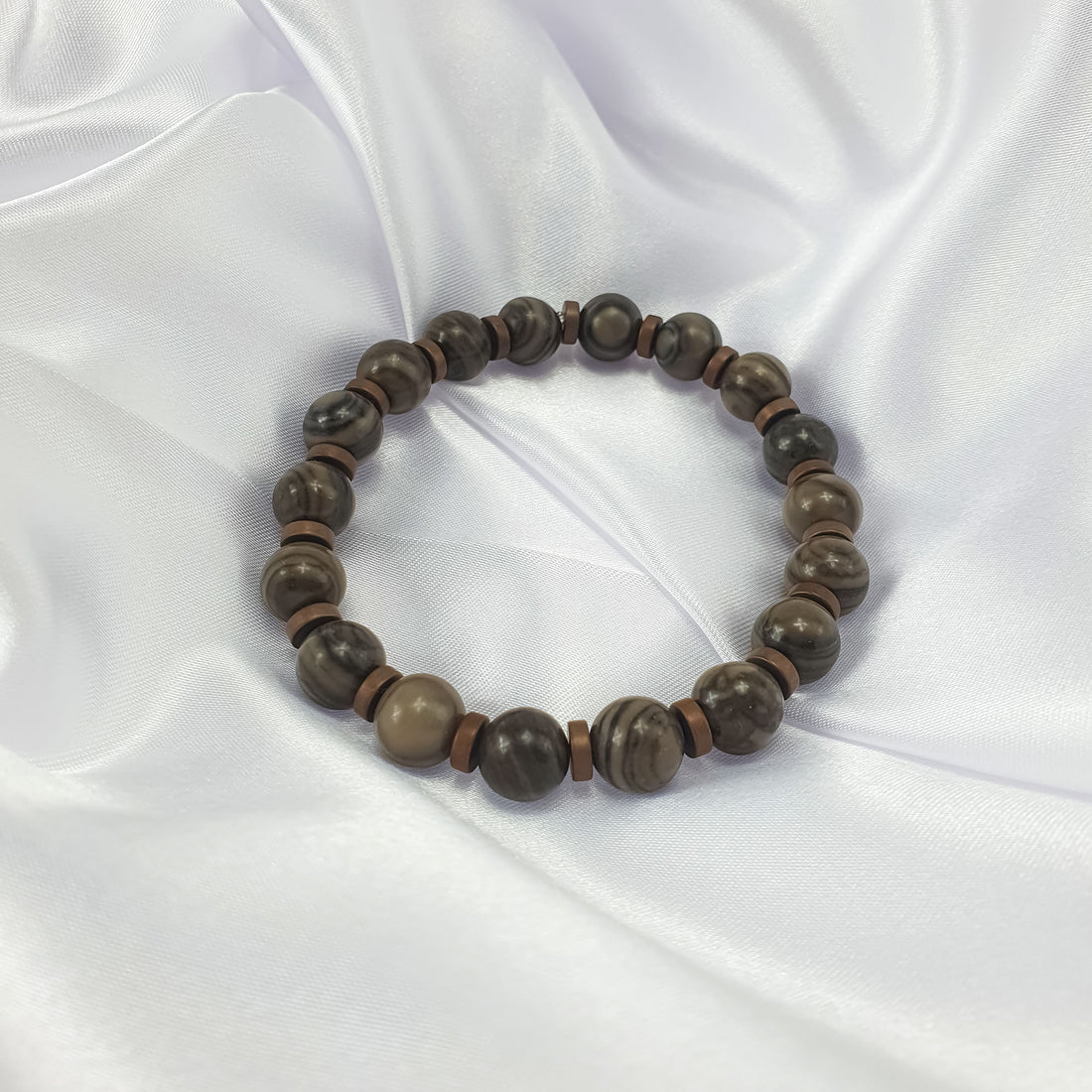 Natural jasper bracelet on white satin, showing the stone texture and matte spacers