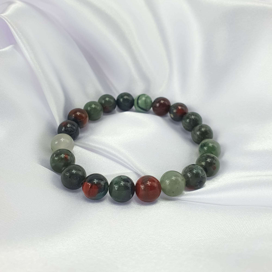 Natural bloodstone bracelet on white satin, vivid red and green contrast