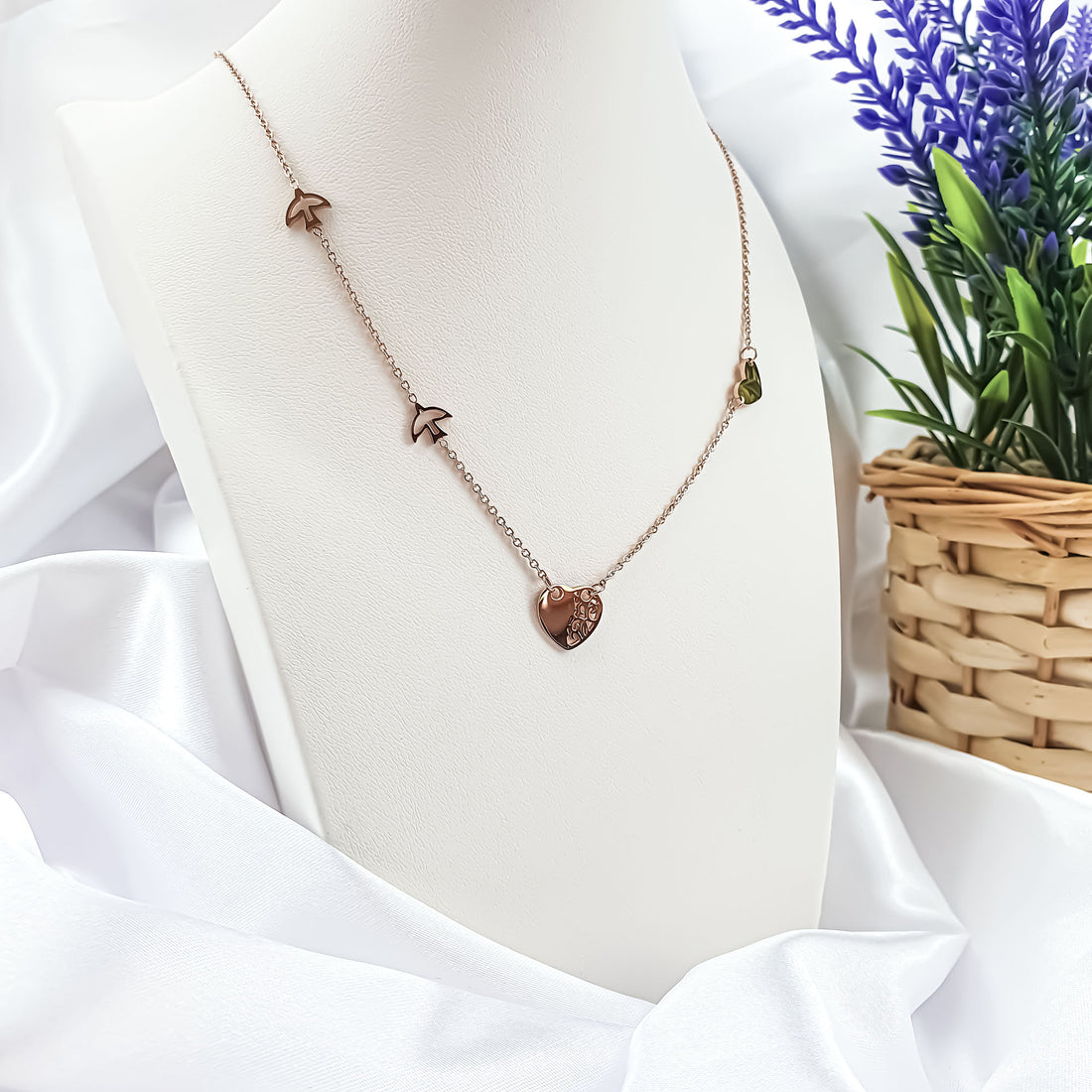 Heart and birds necklace on a white jewellery stand