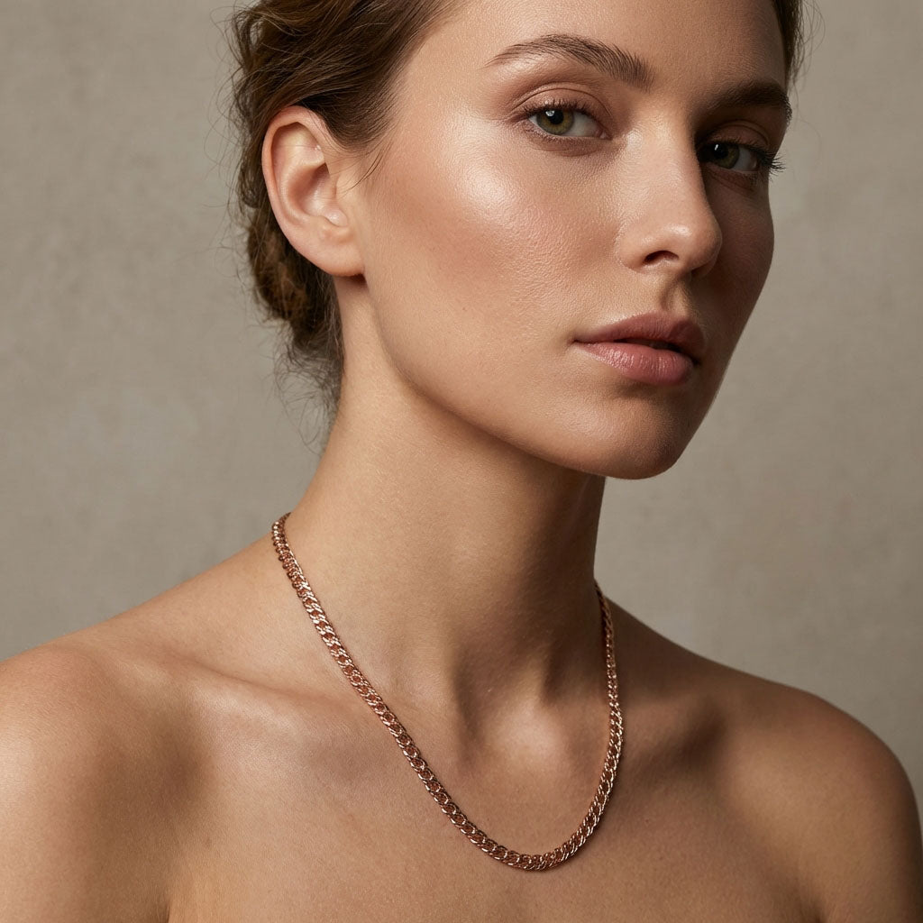 Model wearing a rose gold tone Rombo chain on bare shoulders
