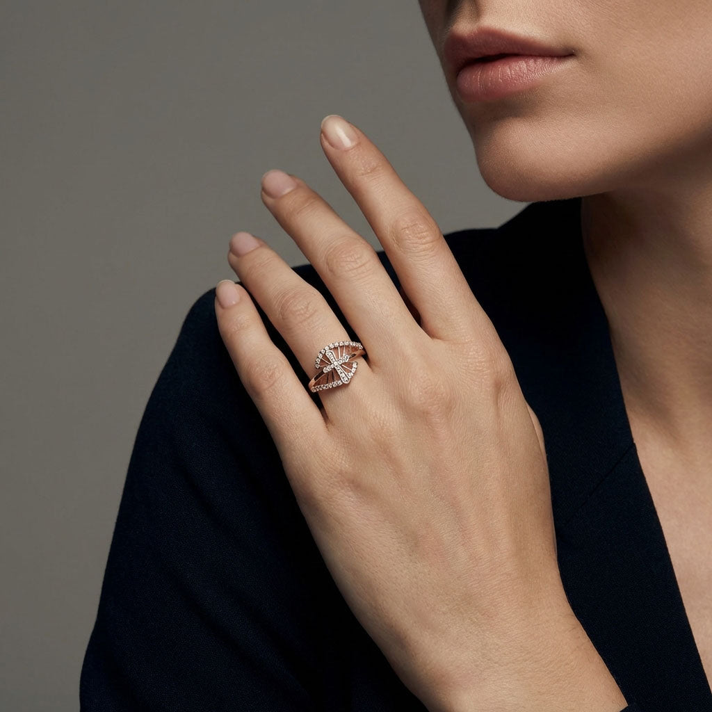 Cross ring with cubic zirconia on a woman's hand, dark jacket, grey background