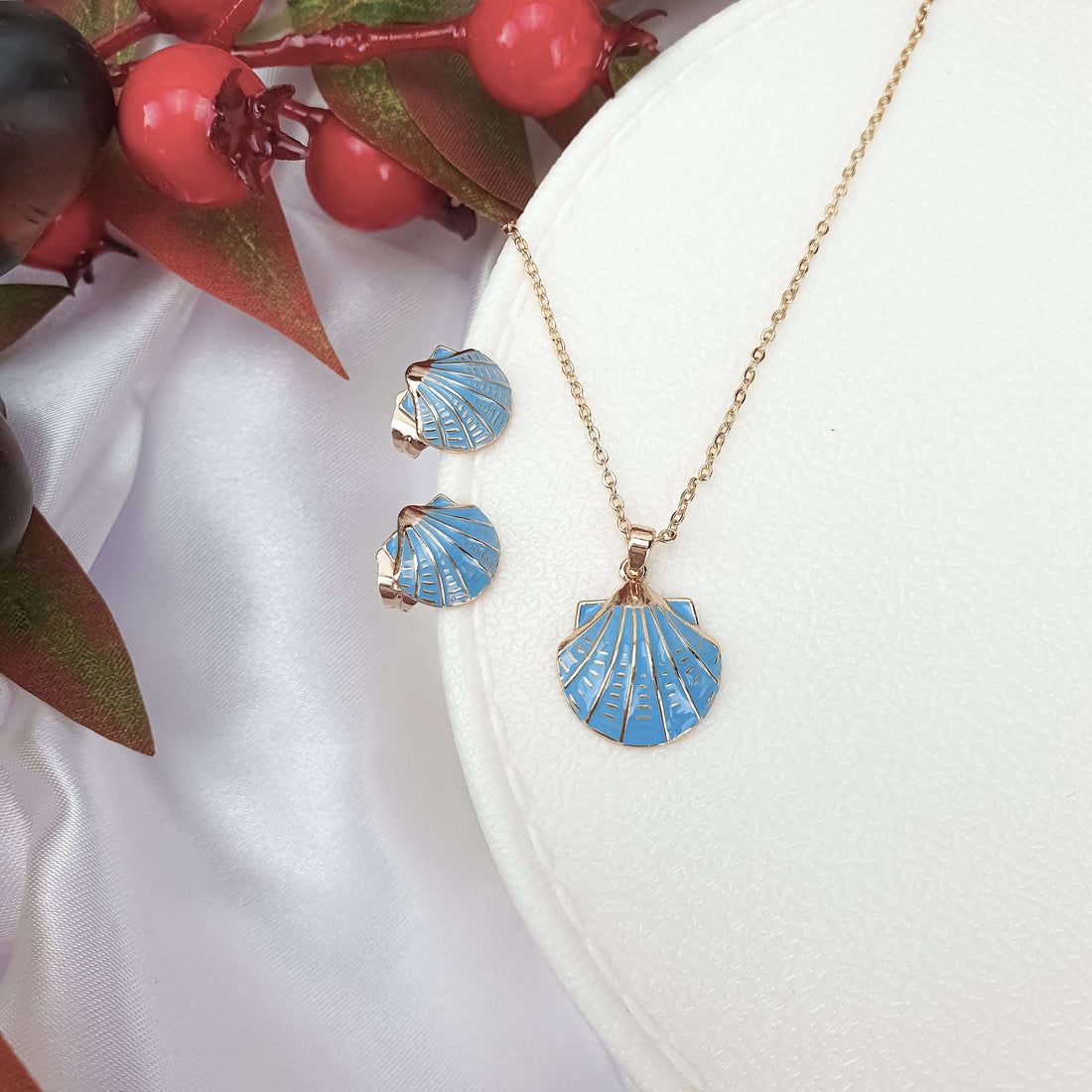 Blue enamel seashell earrings and pendant, gold-plated, on a white jewellery box