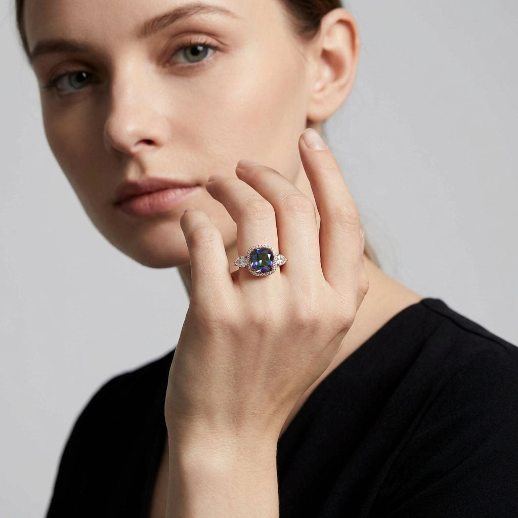 Model in a black blouse wearing a ring with a blue-green crystal
