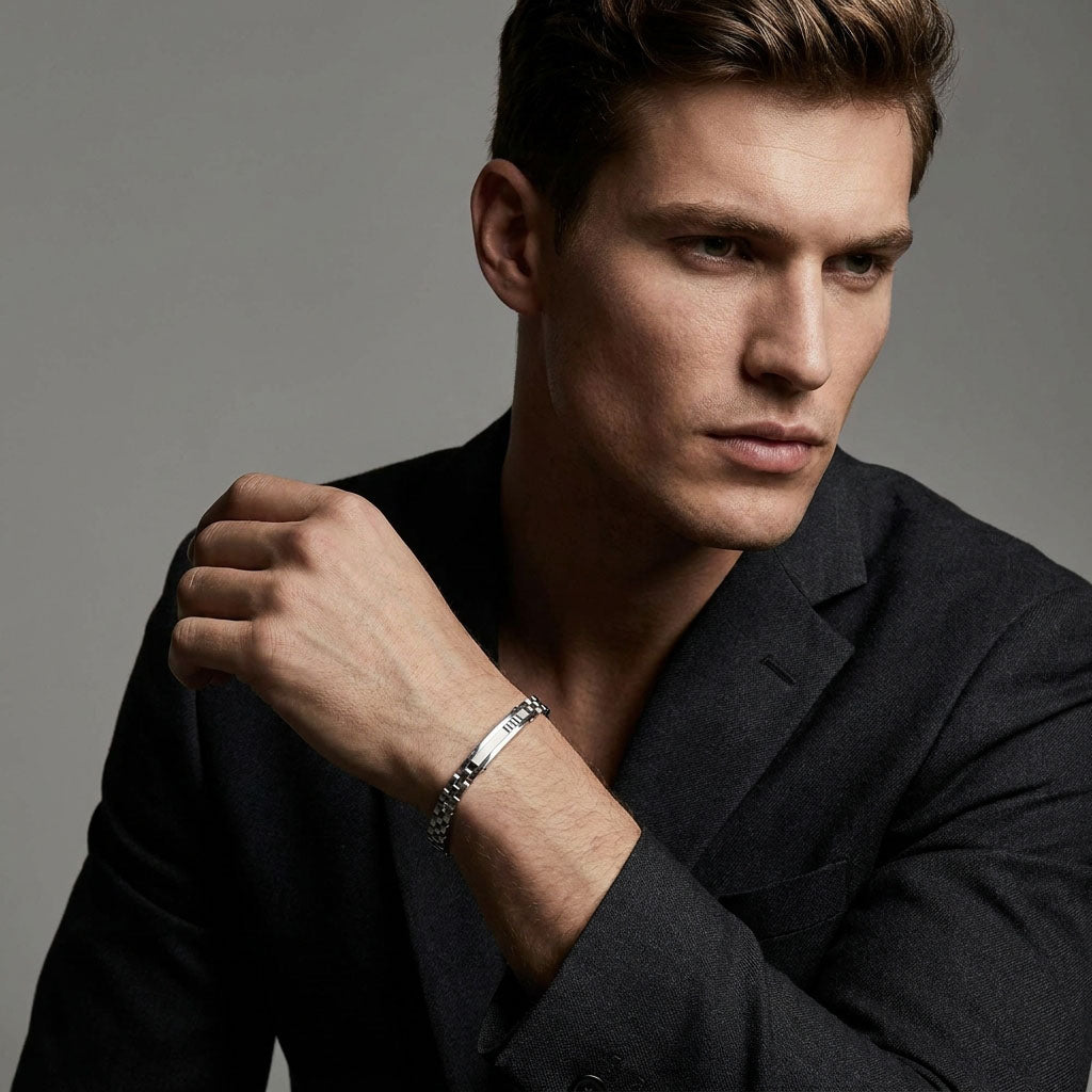 Man in a dark suit wearing a silver-tone link bracelet on his wrist