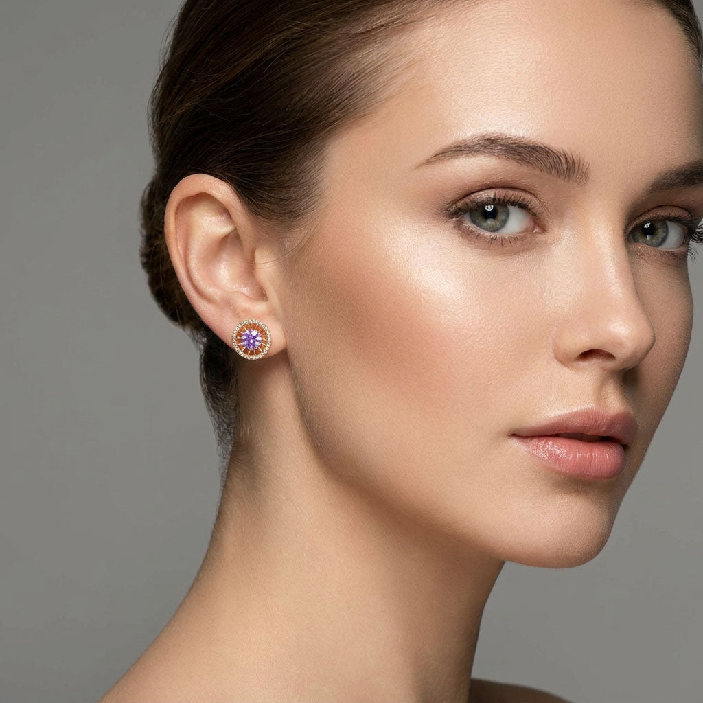 Model wearing round gold-plated studs with a violet stone in a white halo