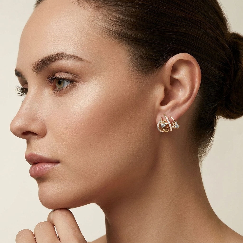 Close-up of a gold-tone bee earring with white stones on a model's ear