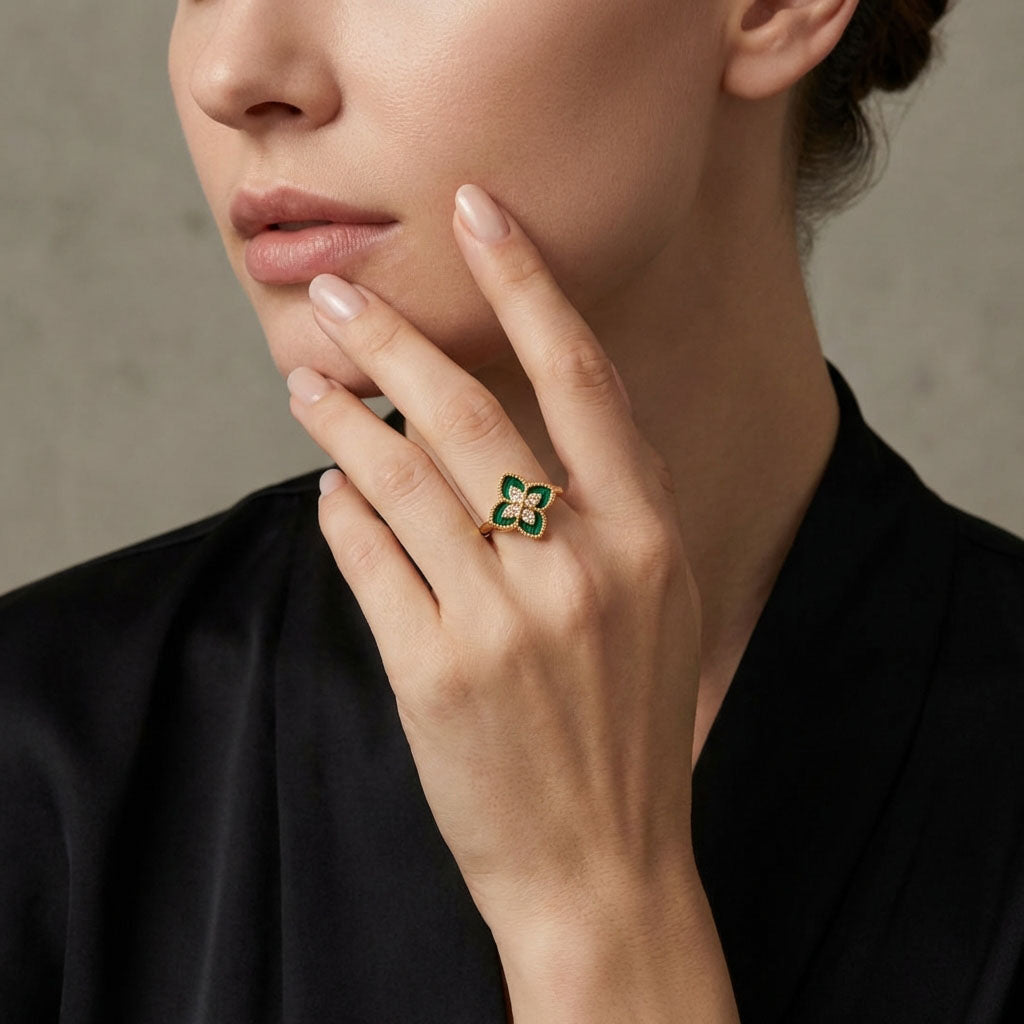 Woman in a black blouse wearing a green enamel clover ring