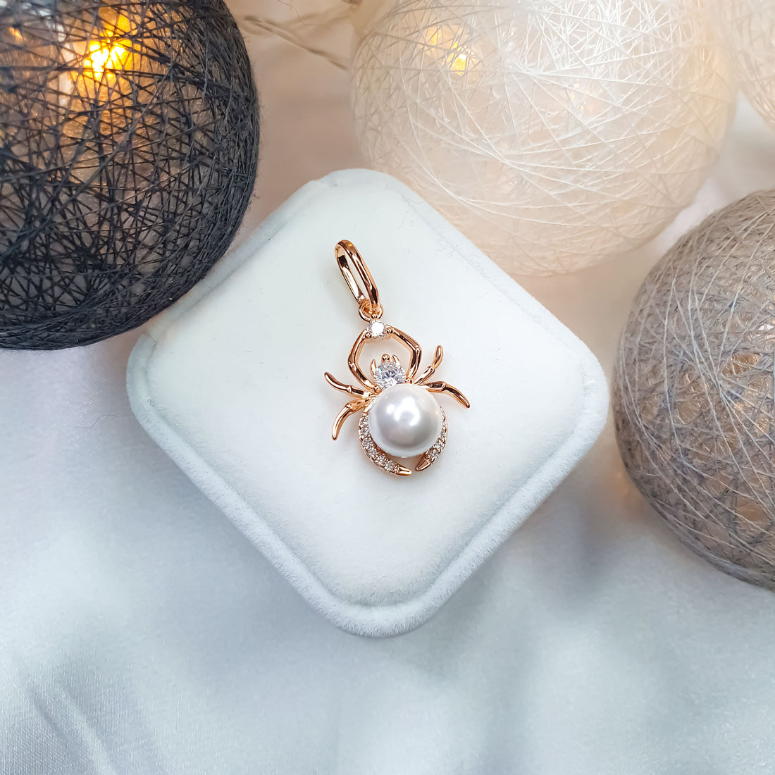 Spider pendant with a pearl and cubic zirconia on a white case