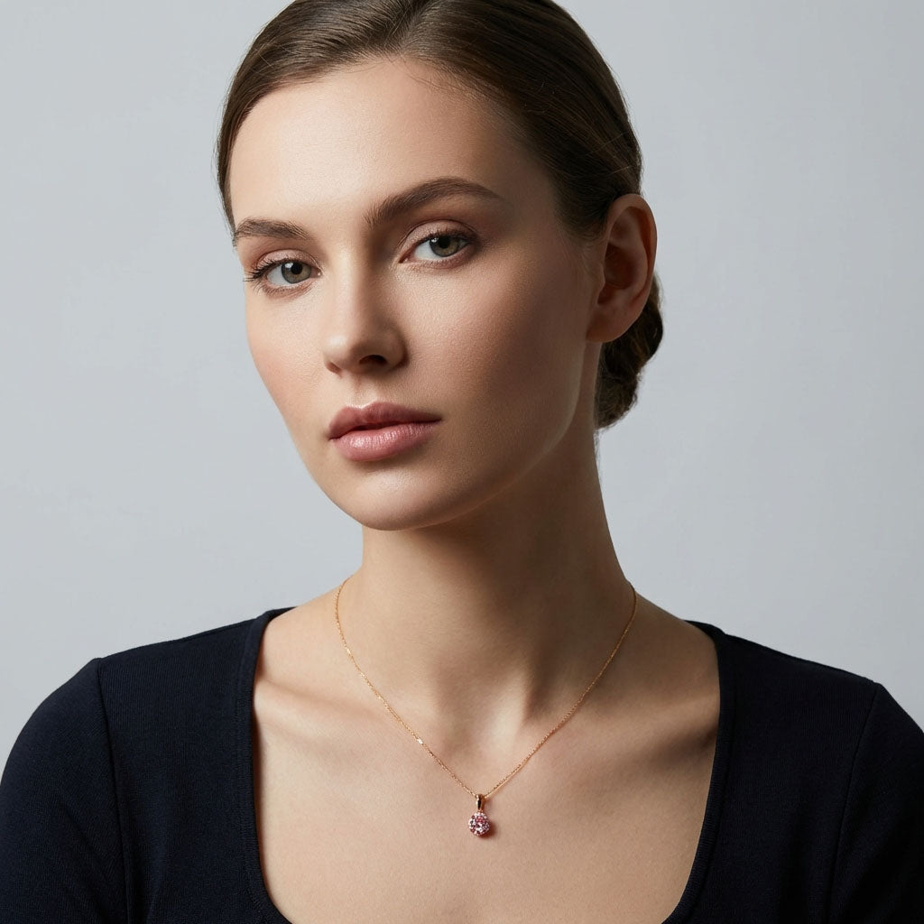 Model in a black top wearing pink pendant on a fine gold-tone chain