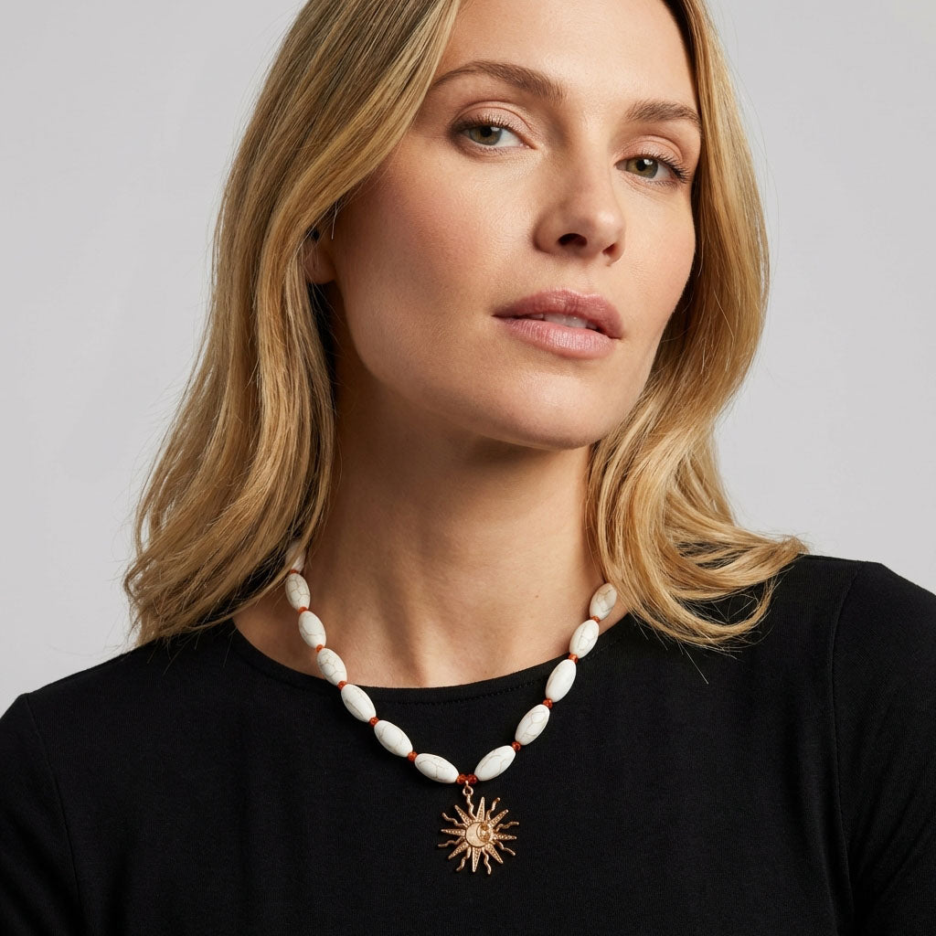 Model in a black jumper wearing white necklace with sun and moon pendant