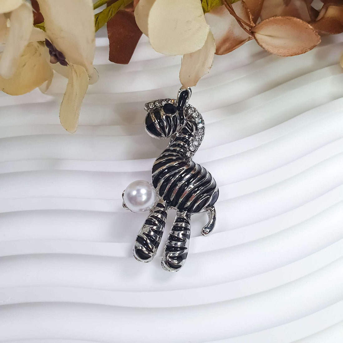 Zebra brooch from the side, clear stones in the mane, white faux pearl