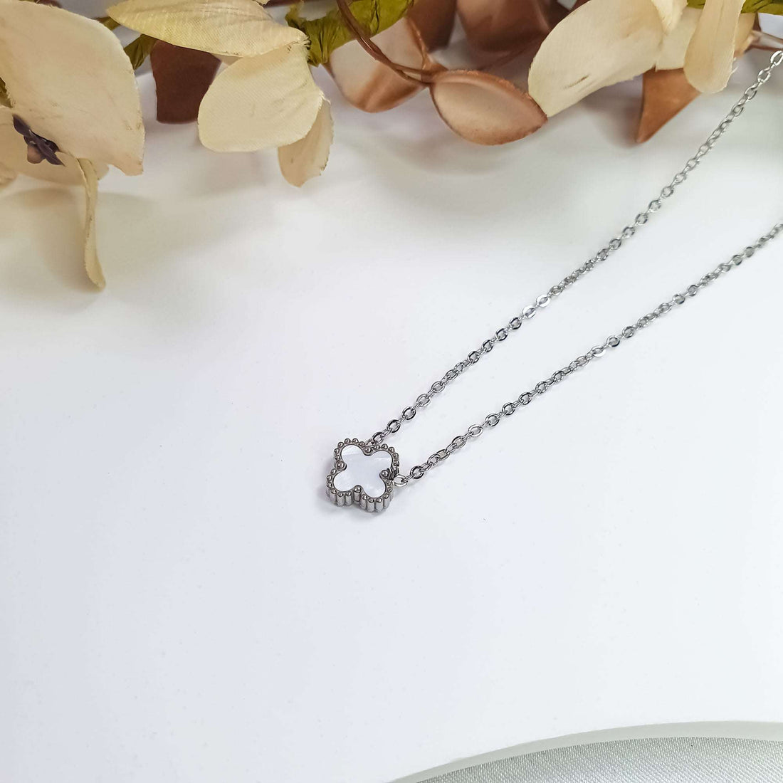 White clover pendant from the side showing its beaded edge