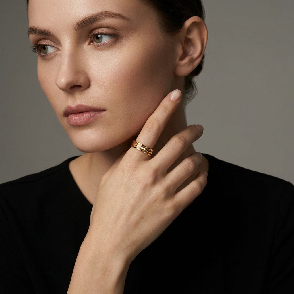 Model wearing the gold-plated three-band ring, hand raised to her cheek