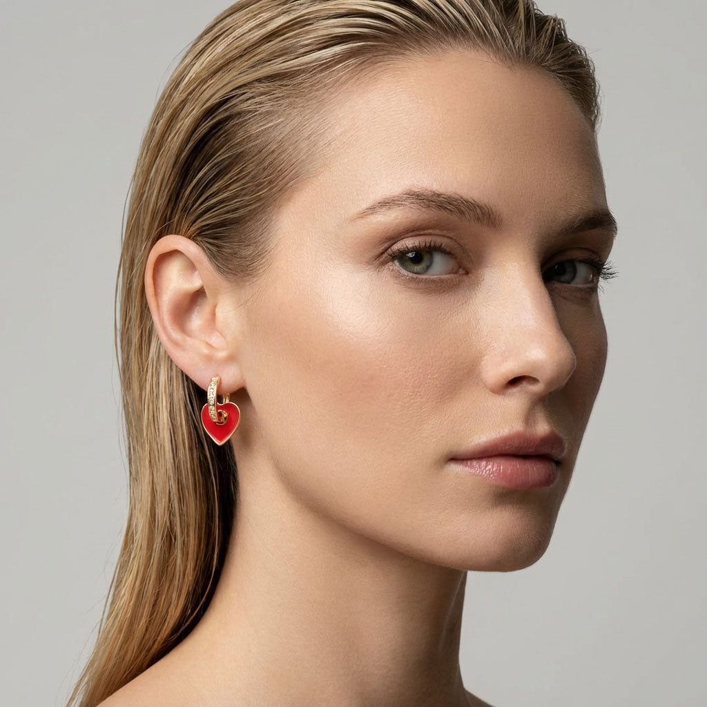 Model wearing a red heart earring on a gold-plated hoop with cubic zirconia