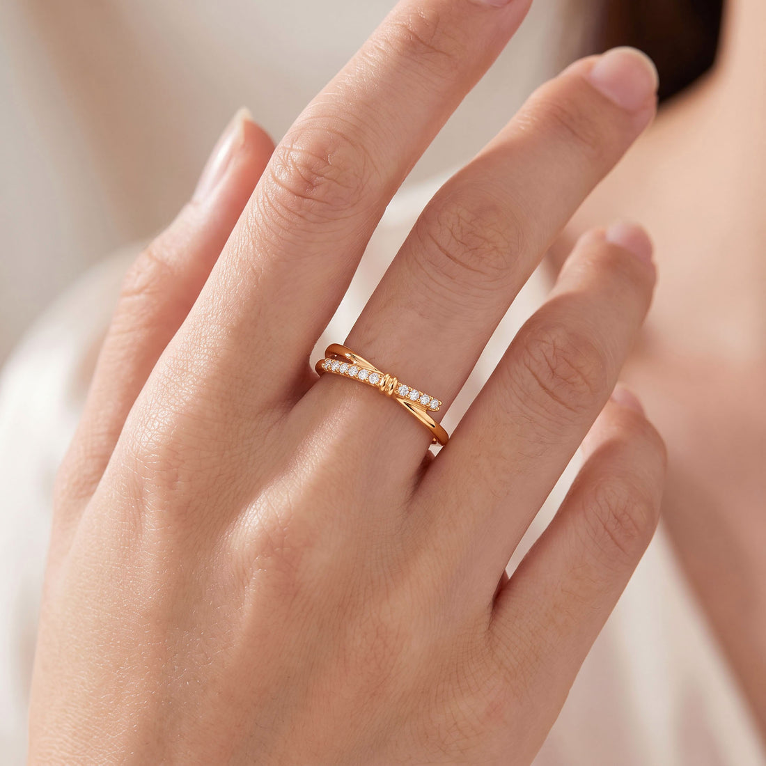 Crossover ring with cubic zirconia worn on a woman's finger