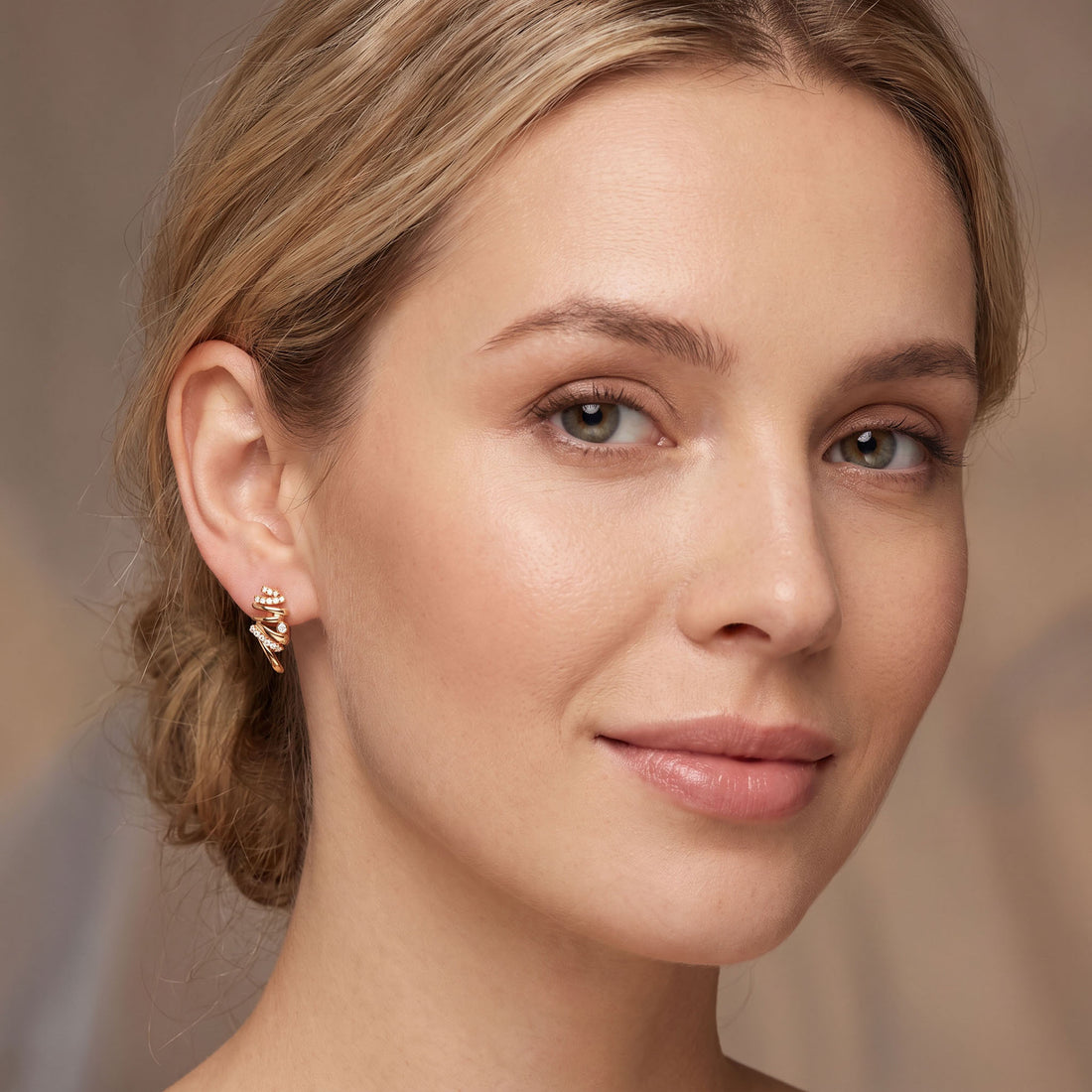 Gold | Gold-tone spiral earring worn on the ear