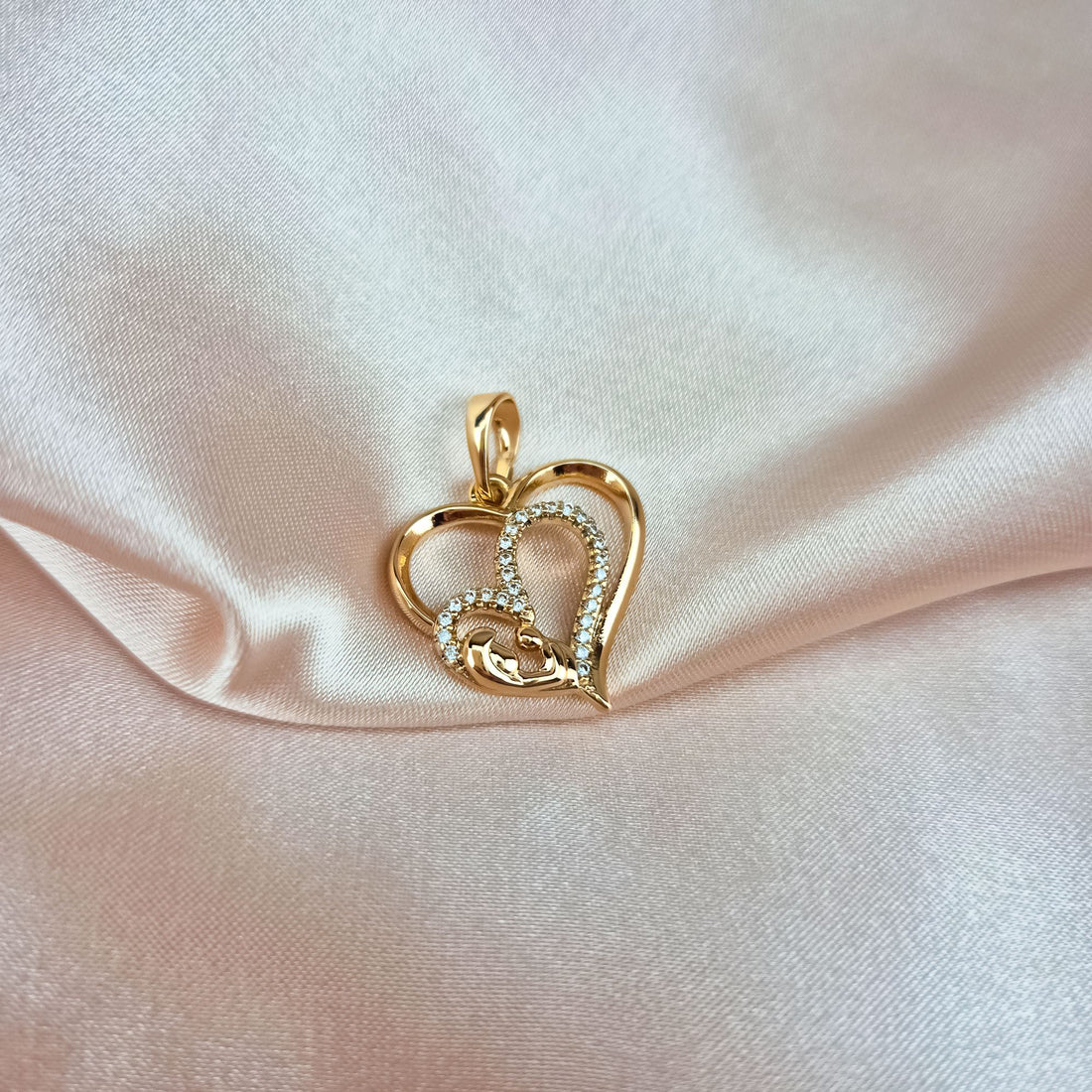Mother and child heart pendant close up on soft pink silk