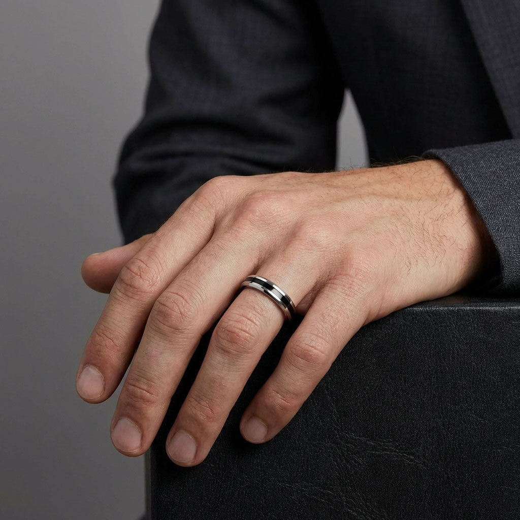 Man in a dark suit wearing a steel ring with a black line