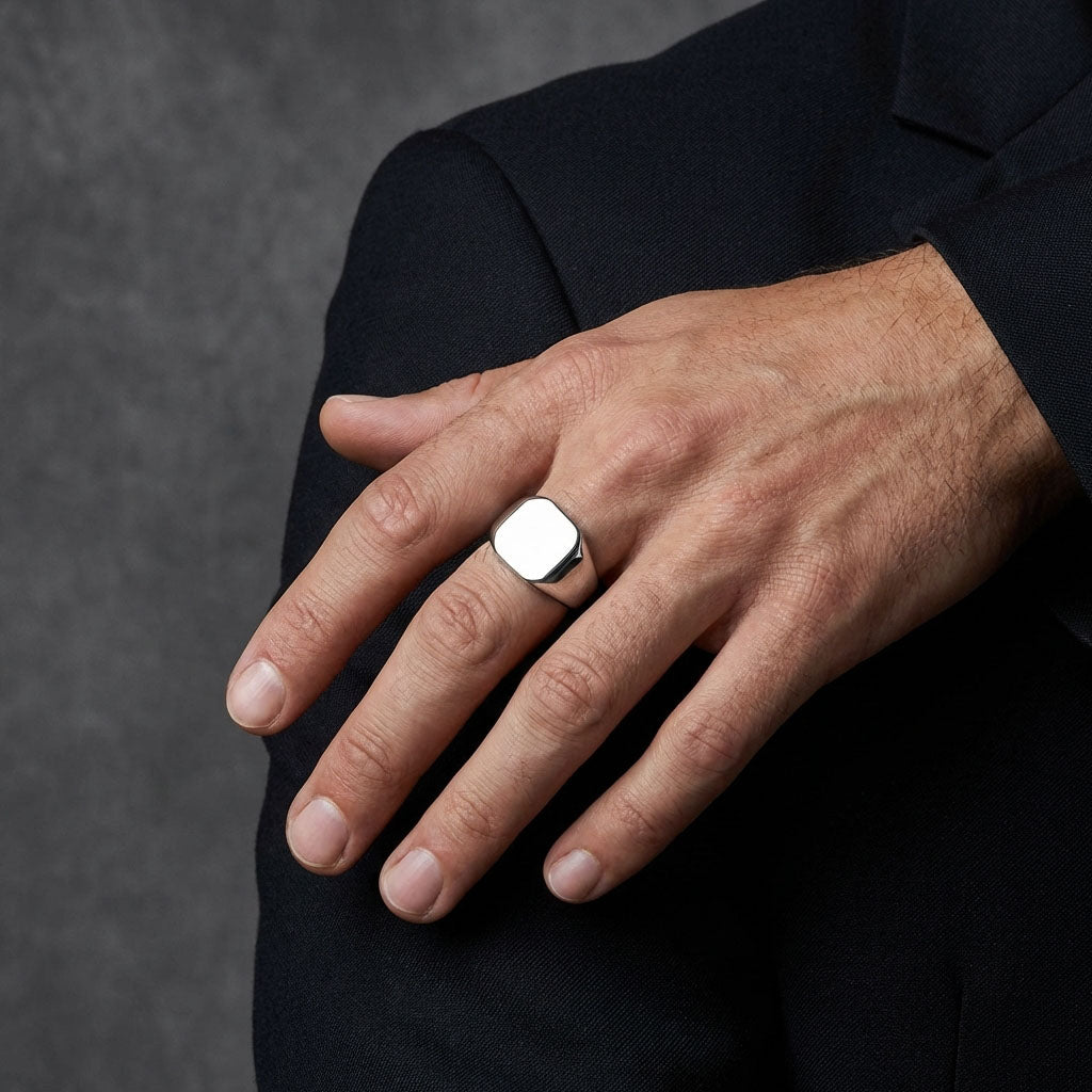 Man in a dark suit wearing the chunky octagonal steel ring