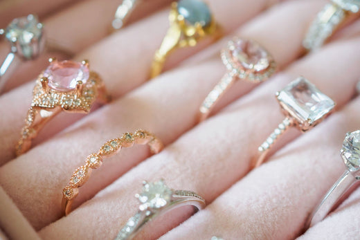 Rings in various widths and settings lined up in a pink velvet box