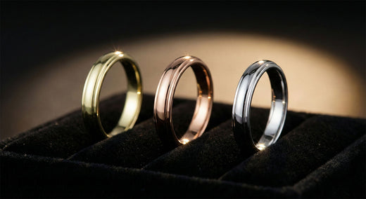 Three plated rings on black velvet in yellow gold, rose gold and silver tones