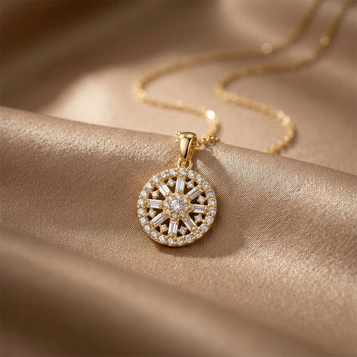 Round gold-plated pendant with cubic zirconia and a fine chain on draped beige silk