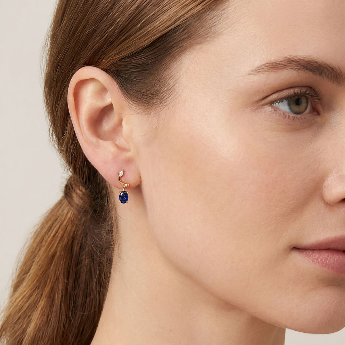 Earrings with a dark blue stone