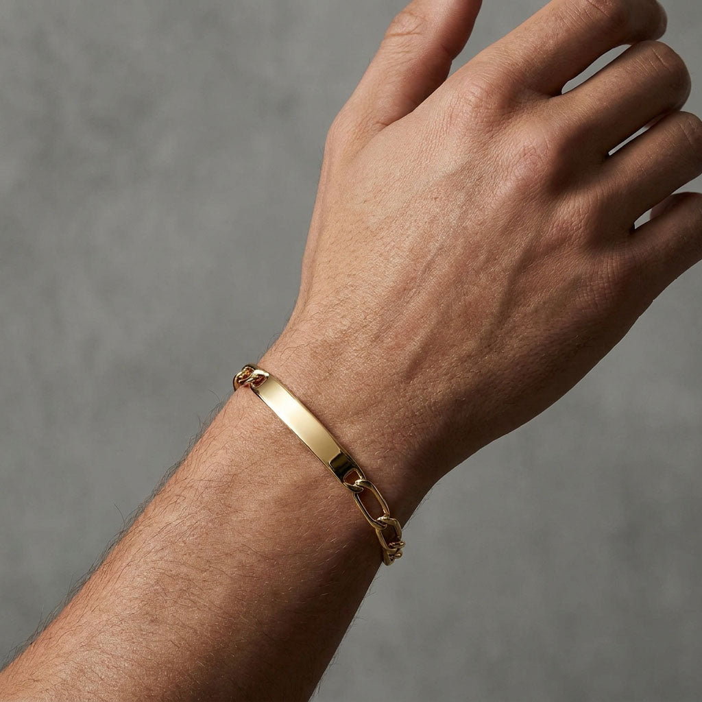 Engravable gold-plated ID bracelet worn on a man's wrist