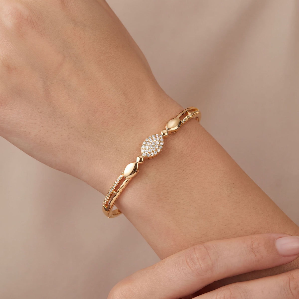 Oval pavé bangle with polished drops worn on a woman's wrist