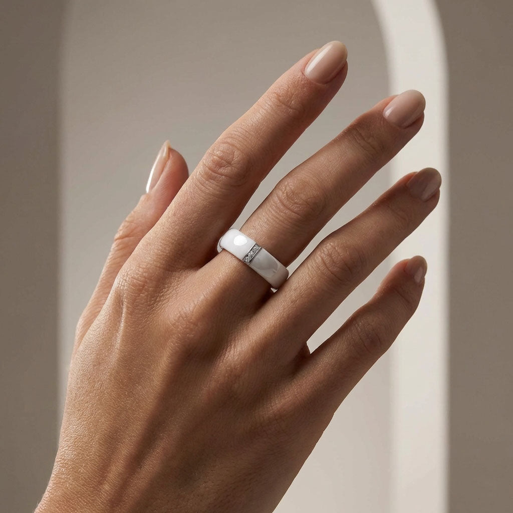 White ceramic ring with a small stone accent on a model's finger