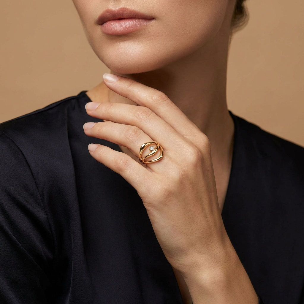 Gold-plated wavy ring with a stone on a model's finger, black blouse