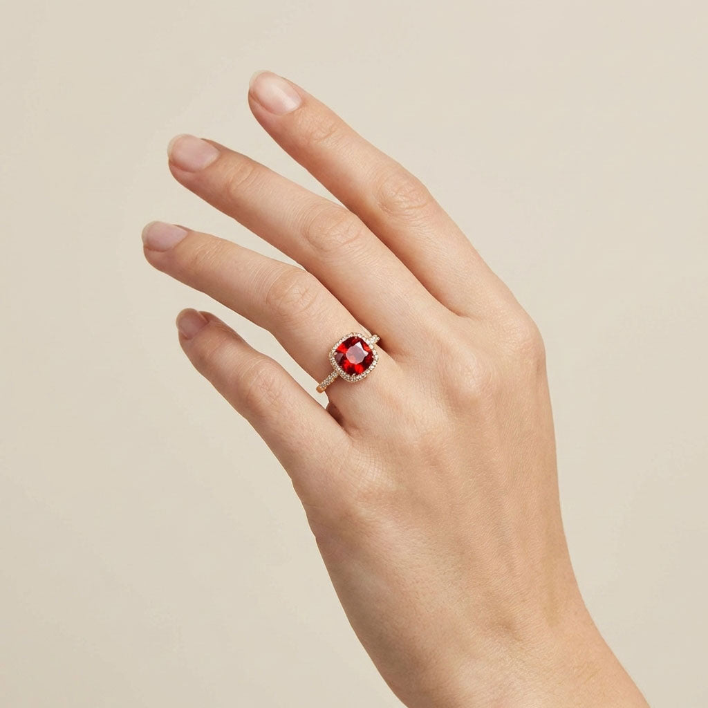 Red stone ring on a model's hand, cubic zirconia halo and slim band