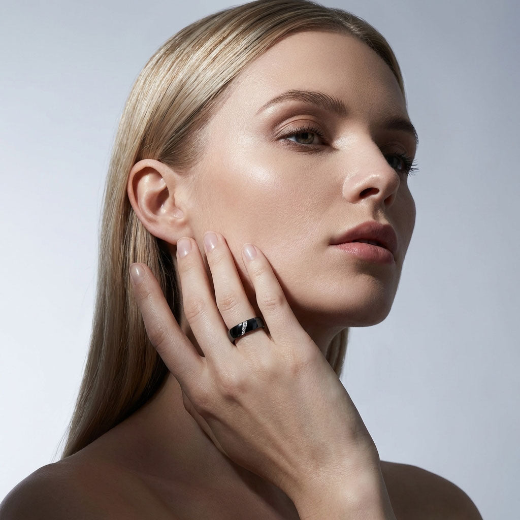 Black ceramic ring on a model's finger against a light background