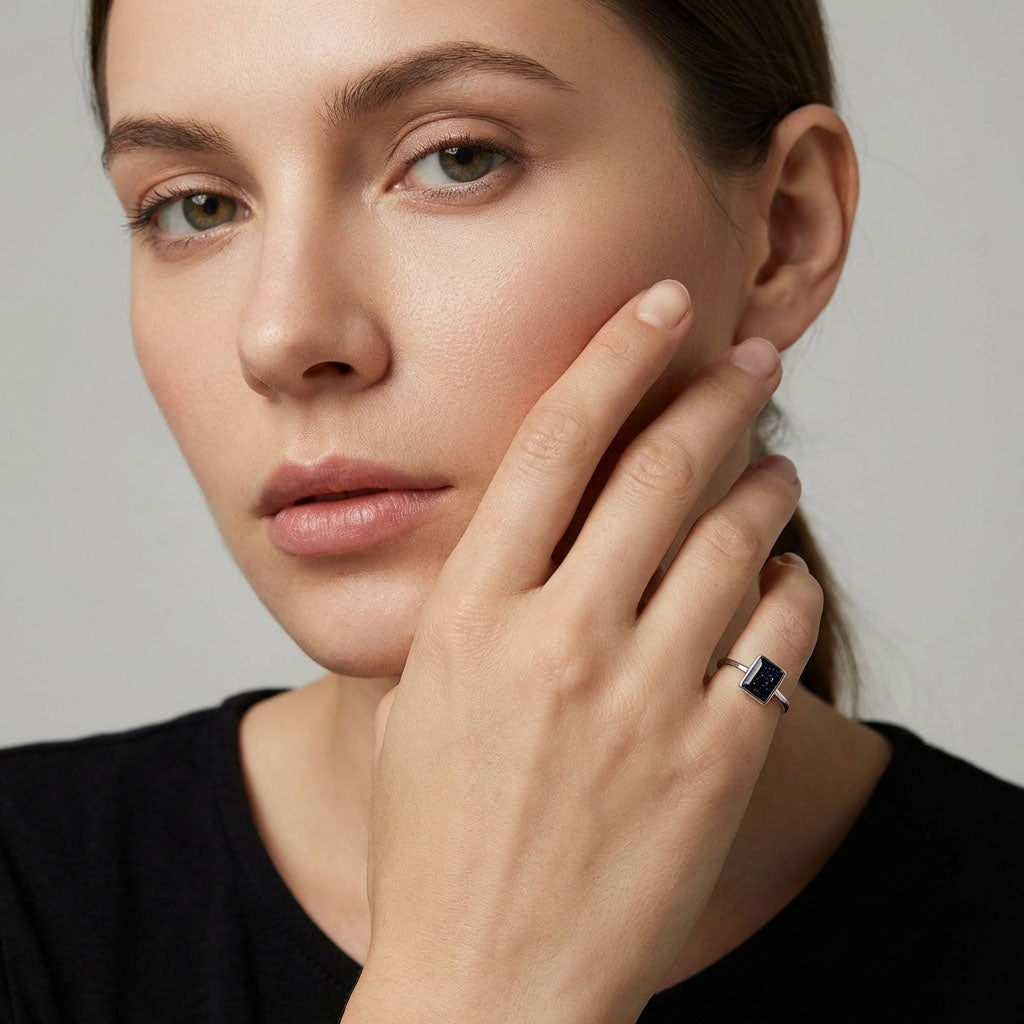Model wearing a slim silver-tone ring, hand near her face