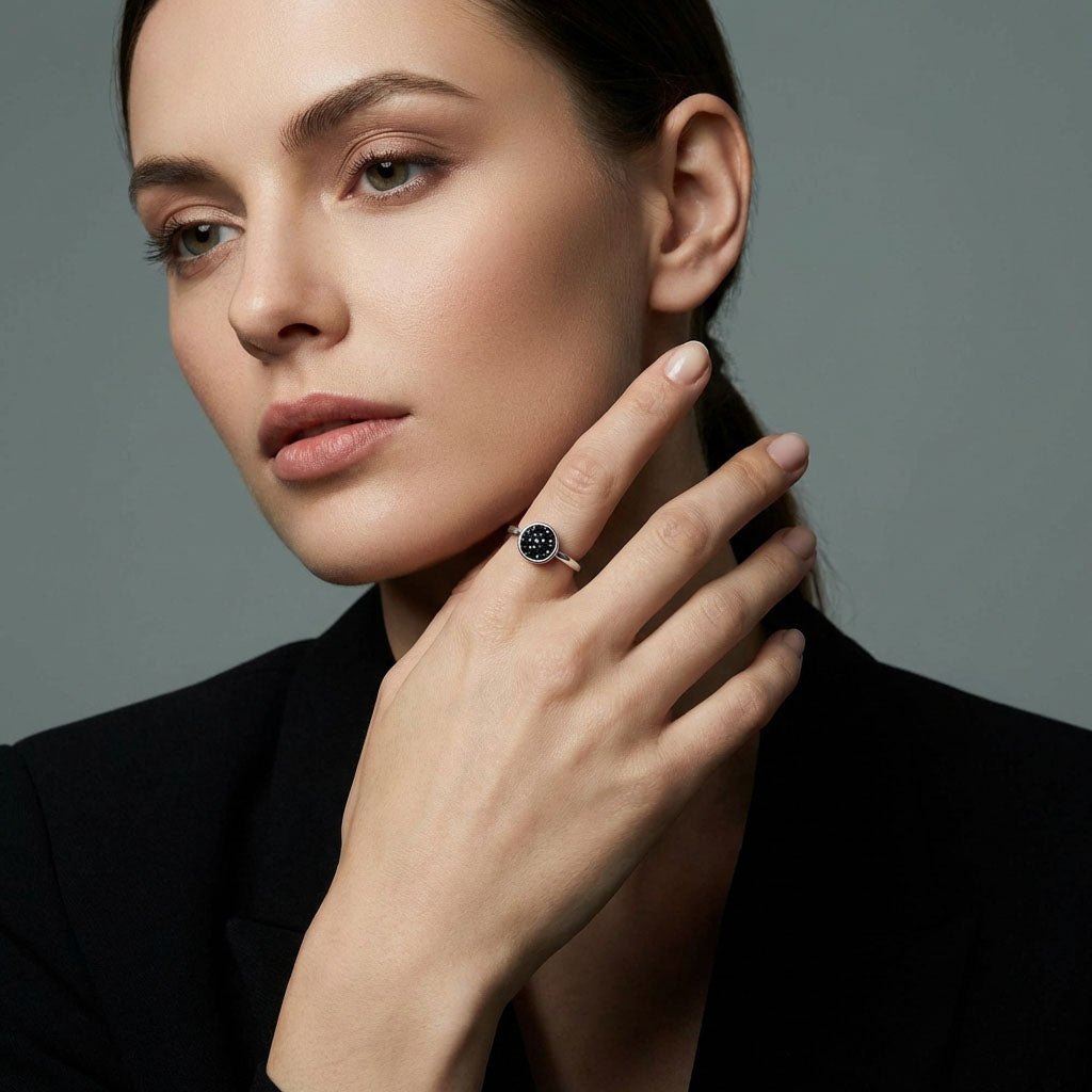 Model wearing the silver-tone ring with a black crystal inlay, hand near her face