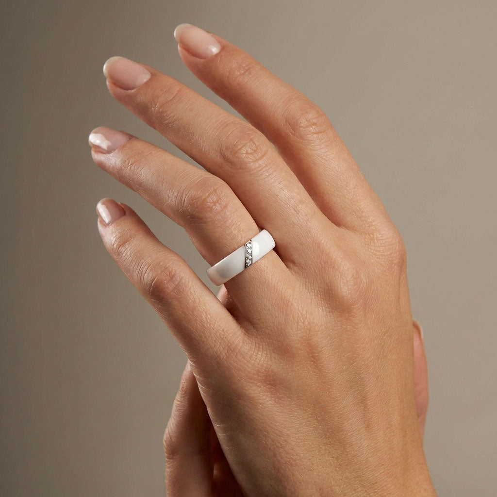White ceramic ring with cubic zirconia on a woman's tanned hand