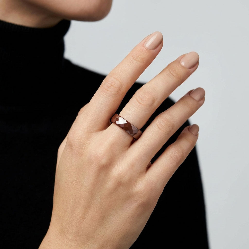 Brown faceted ceramic ring on a woman's finger, black polo neck