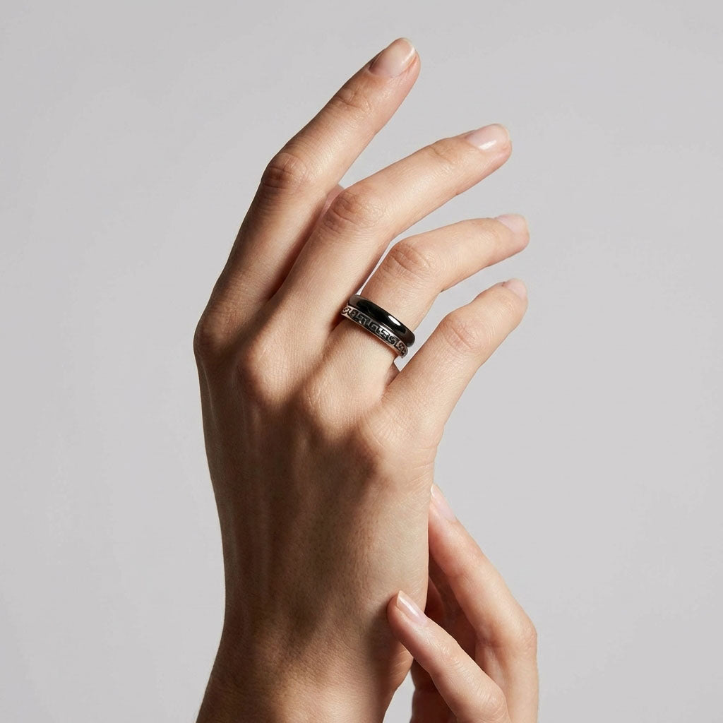 Black ceramic ring and patterned band worn together on a model's finger