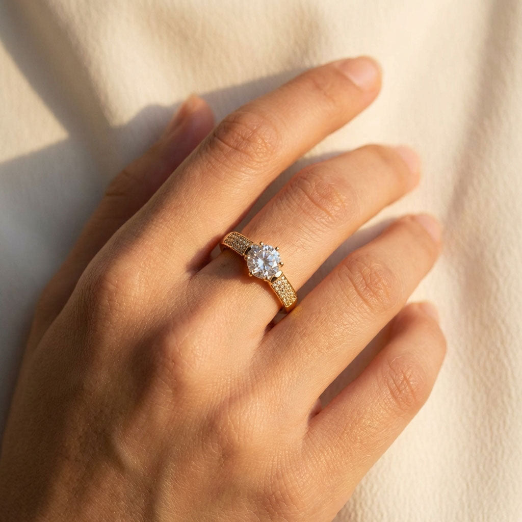 Gold-plated ring with sparkling cubic zirconia on a woman's finger, beige fabric