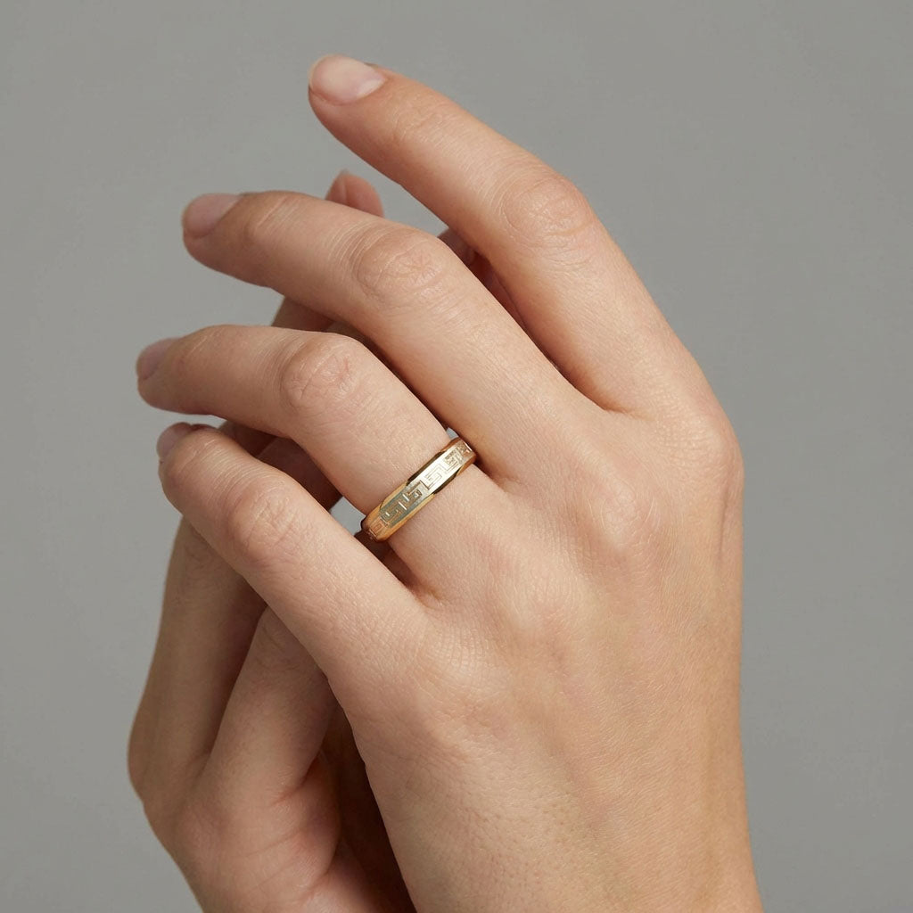 Two-tone meander ring on a model's finger, gold-plated with a silver-tone stripe